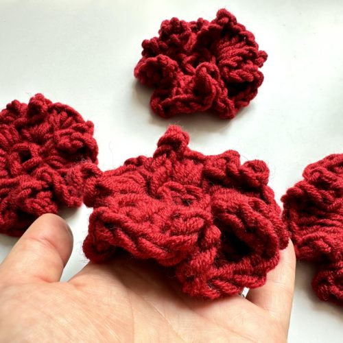 Kwiaty na szydełku burgundowe bordowe na sweter na szydełku z włóczkim burgundowe dodatki jesien 2025 modne burgundowy sweter z kwiatami burgundowe stylizacje